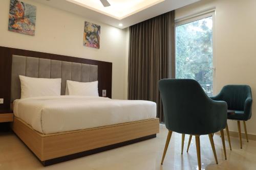 グルガオンにあるHotel Gurugramのベッドルーム1室(ベッド1台、椅子2脚付)