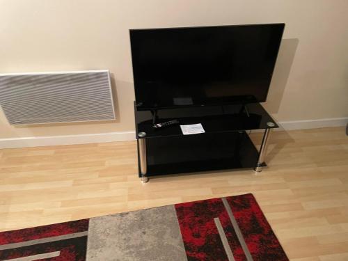 a flat screen tv sitting on a stand in a room at High vibes home in Chelmsford