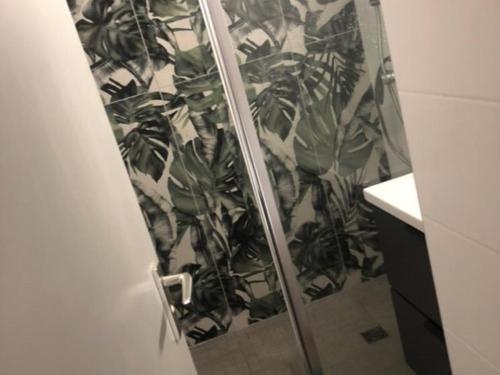 La salle de bains est pourvue d'une douche avec une plante. dans l'établissement Appartement T2 avec grande terrasse, parking, animaux admis et piscine - FR-1-195-94, au Barcarès