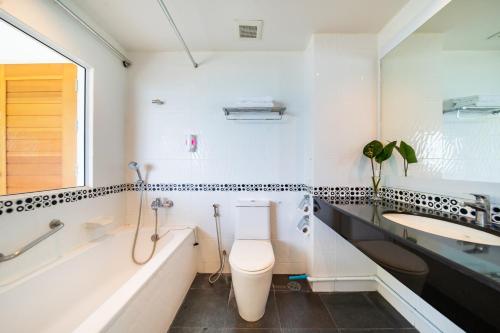 a white bathroom with a toilet and a sink at Best Bella Pattaya in Pattaya North