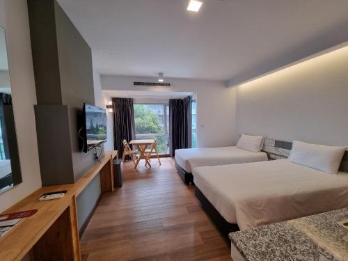 um quarto de hotel com duas camas e uma televisão de ecrã plano em The Key Point Hotel em Bangkok