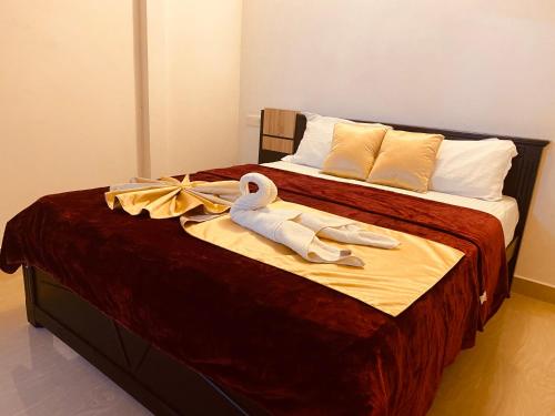 a bed with two swans and towels on it at Alice Lake Promise in Alleppey