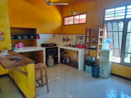 uma cozinha com paredes amarelas e um balcão em Casa Minha Backpackers Hostel em Dili