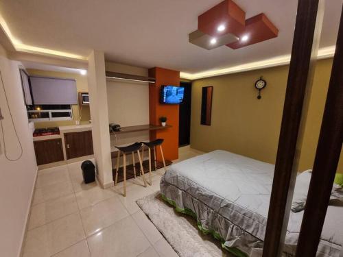 a bedroom with a bed and a kitchen with a table at Departamentos fresno! Tu mejor opción in Toluca
