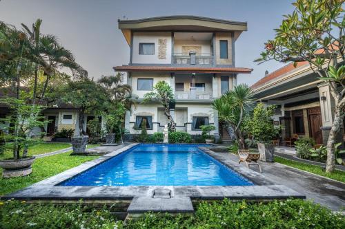 a house with a swimming pool in front of it at Gria Umasari Sanur in Sanur