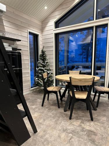 een patio met een tafel en stoelen en een kerstboom bij Norvamaja with a lake view, sauna and jacuzzi in Rovaniemi