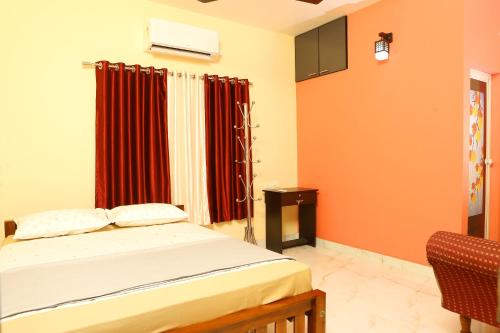 a bedroom with a bed and red curtains at PAUL'S HOME STAY in Cochin