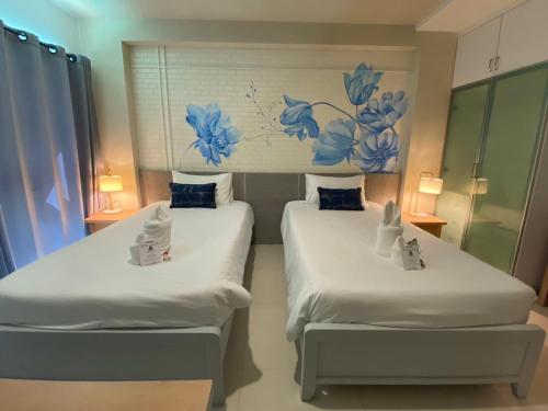 - 2 lits dans une chambre avec des fleurs bleues sur le mur dans l'établissement Phi Phi Indigo Hotel, sur les Îles Phi Phi