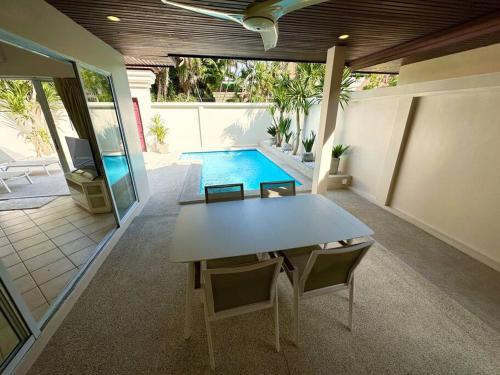 a dining room with a table and a swimming pool at View Talay Villas - Luxury, 2 Bedroom - private pool villa, 500m from Jomtien beach - VTV 86 in Jomtien Beach