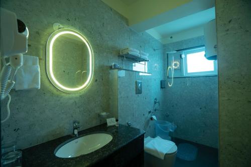 a bathroom with a sink and a mirror and a toilet at Mount Magnolia Boutique Hotel & Spa in Pelling