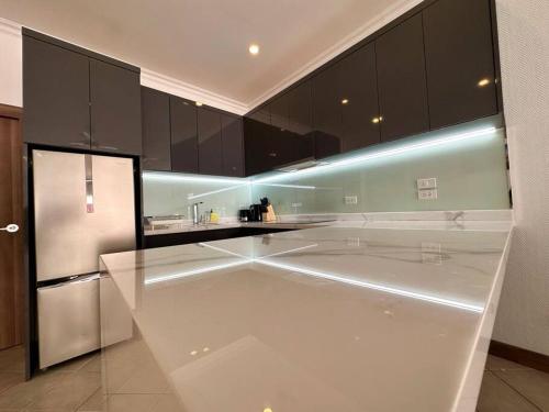 a kitchen with black cabinets and a stainless steel refrigerator at View Talay Villas - Luxury, 2 Bedroom - private pool villa, 500m from Jomtien beach - VTV 86 in Jomtien Beach