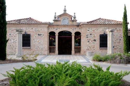 a stone building with a clock on top of it at Hotel Cigarral el Bosque in Toledo
