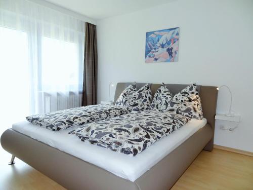 - un lit avec des draps et des oreillers en noir et blanc dans l'établissement Holiday flat, Axams, à Innsbruck