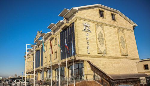 a building with a sign on the side of it at Royal Grand Hotel, Turkistan in Türkistan