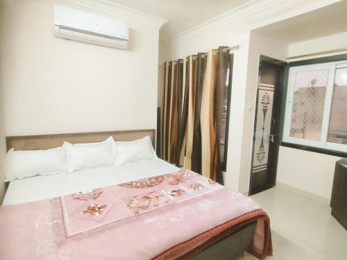 ein Schlafzimmer mit einem Bett mit einer rosa Decke darauf in der Unterkunft Hotel Shree chandram - 10min walking distance to श्रीNathji temple in Nāthdwāra