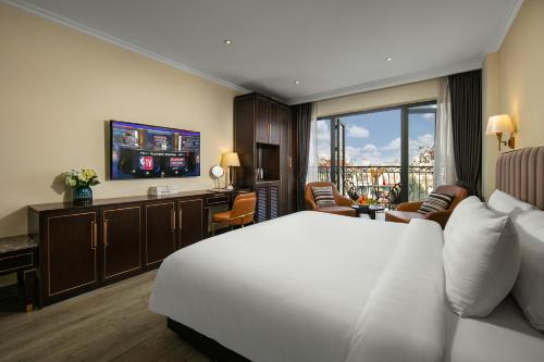 um quarto de hotel com uma cama branca e uma televisão em San Palace Hotel & Spa em Hanói