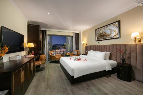 um quarto de hotel com uma cama grande e uma sala de estar em San Palace Hotel & Spa em Hanói