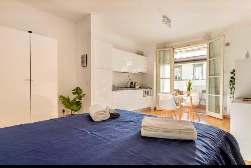 a bedroom with a blue bed with towels on it at Florence Green Apartment in Florence
