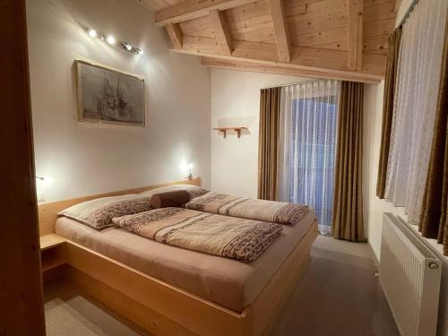 1 dormitorio con 1 cama en una habitación con ventana en Appartement Thurnbach, en Aschau