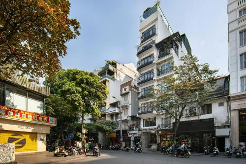 a group of people riding motorcycles down a city street at San Palace Hotel & Spa in Hanoi