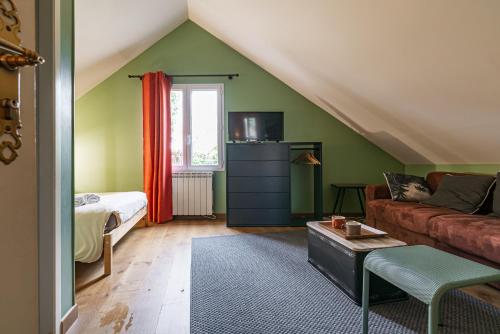 uma sala de estar com um sofá e uma cama em B&B des Marcs d'Or em Dijon