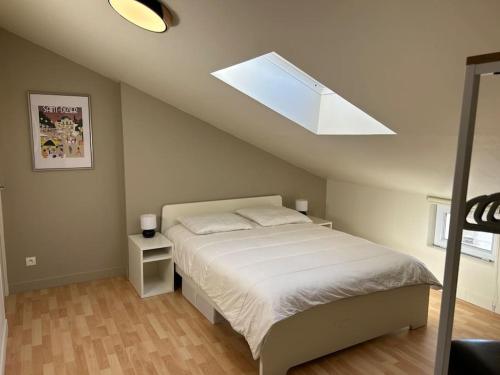 sypialnia z łóżkiem i świetlikiem w obiekcie Grand appartement de standing w mieście Saint-Dizier