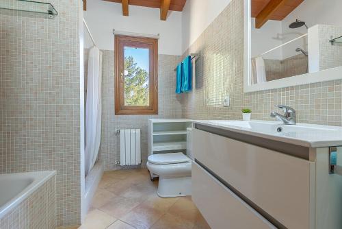 uma casa de banho com um lavatório, um WC e uma banheira em Townhouse Sonrisa by Homevillas360 em Artà