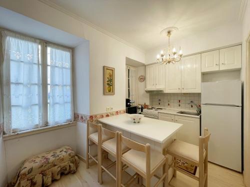 eine Küche mit einem Tisch und Stühlen sowie einem Kühlschrank in der Unterkunft Flora in Nafplia in Nafplio