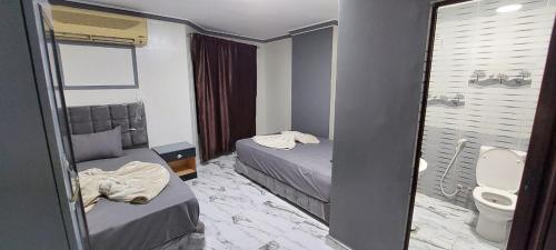 Cette petite chambre comprend 2 lits et des toilettes. dans l'établissement Best Dreams Hotel, au Caire