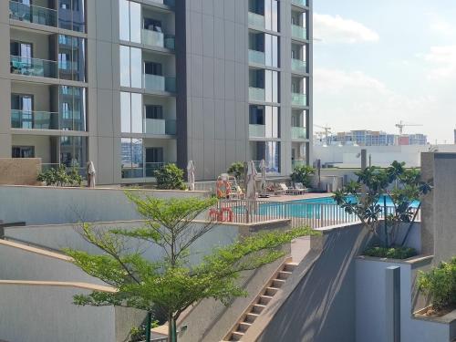 an apartment building with a swimming pool and trees at Modern 1 bedroom - Close to Business Bay - Sobha Creek Vista in Dubai