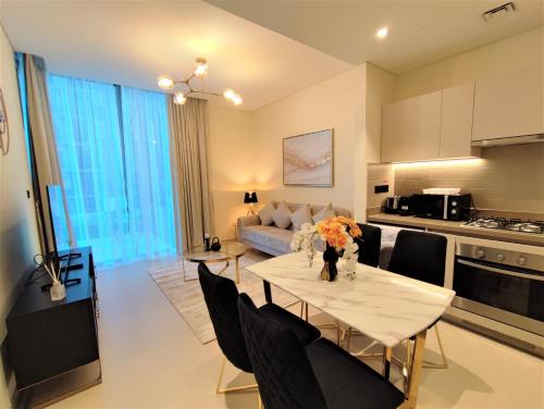 a kitchen and living room with a table and chairs at Modern 1 bedroom - Close to Business Bay - Sobha Creek Vista in Dubai