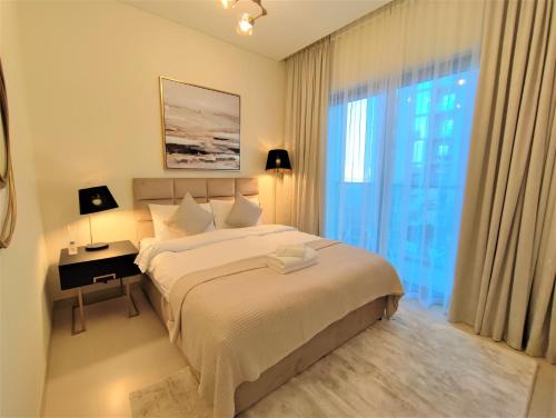 a bedroom with a bed and a desk and a window at Modern 1 bedroom - Close to Business Bay - Sobha Creek Vista in Dubai