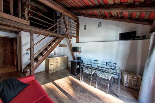 ein Wohnzimmer mit einem roten Sofa und einem Tisch in der Unterkunft Agriturismo Rivet d'Or in Pragelato