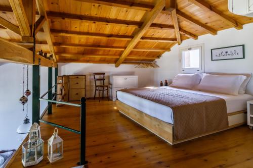 a bedroom with a large bed and wooden ceilings at Vivere Skopelos in Skopelos Town