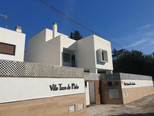 a white building with a sign that reads walt haditz at VILLA TAZA DE PLATA A in Huétor Vega