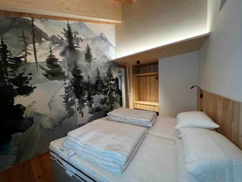 two beds in a room with a painting on the wall at YETI Design mountain apartments in Valdidentro