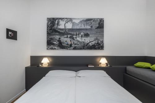 a bedroom with a bed and a painting on the wall at Bertamini Apartments in Nago-Torbole