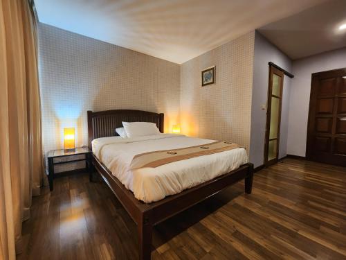a bedroom with a large bed with two lamps on it at August Residence in Bangkok