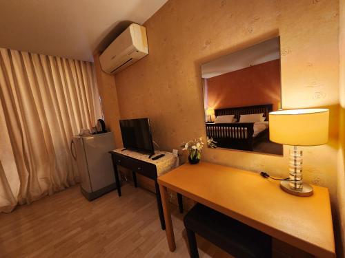 a room with a desk with a computer and a mirror at August Residence in Bangkok
