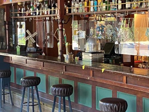 un bar con taburetes negros delante en Hotel Cafe The Windmill, en Schiedam