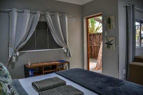 a bedroom with a bed and a window at Biki Plek 2 in Kimberley