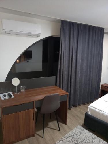 a hotel room with a desk and a bed and a bedroom at Prenoćište Srebrno Jezero in Veliko Gradište