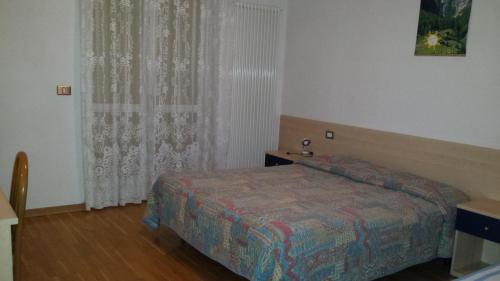 1 dormitorio con cama y ventana en Appartamenti hotel ortles en Cogolo