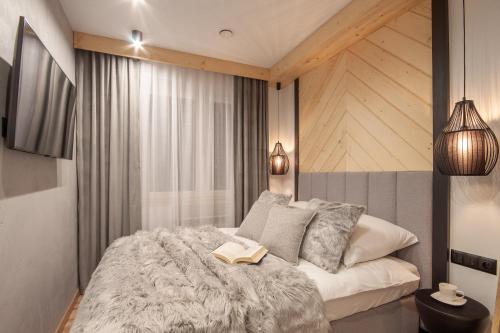 sypialnia z łóżkiem z książką w obiekcie Apartamenty u Zajączków w Zakopanem