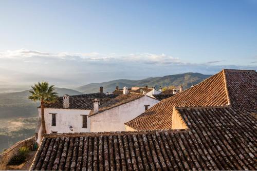a group of roofs with mountains in the background at Hotel Tugasa Castillo de Castellar in Castellar de la Frontera
