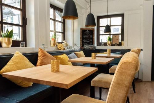 un restaurante con mesas y sillas de madera y ventanas en Hotel Kavala en Lohmar