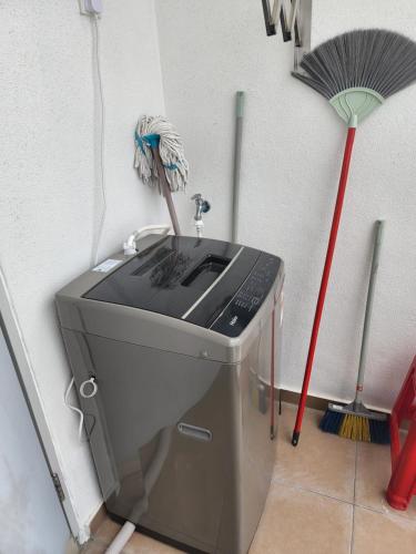 a washing machine in a corner with a broom at Praicon Tower - Premium Suite in Butterworth