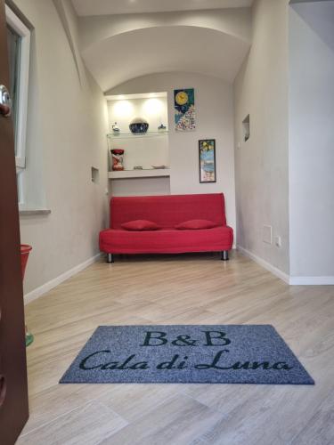 a red couch in a living room with a rug at Cala Di Luna House in Vietri sul Mare