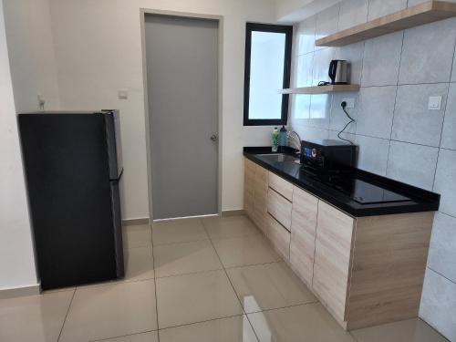 a kitchen with a black refrigerator in a room at Praicon Tower - Premium Suite in Butterworth