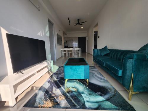 a living room with a blue couch and a tv at Praicon Tower - Premium Suite in Butterworth